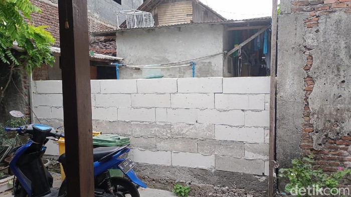 Muhammad Ridwan bingung. Warga Rungkut Menanggal, Surabaya ini bingung karena jalan keluar masuk rumahnya ditutup tembok oleh tetangganya.