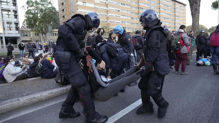 Sibuknya Polisi Italia Tangani Pendemo KTT G20 Italian Police remove climate activists trying to block traffic in front of the Italian Ministry of the Ecological Transition in Rome's via Cristoforo Colombo, one of the main road leading to La Nuvola (the cloud) convention center where the G20 summit is taking place, Saturday, Oct. 30, 2021. (AP Photo/Luca Bruno)