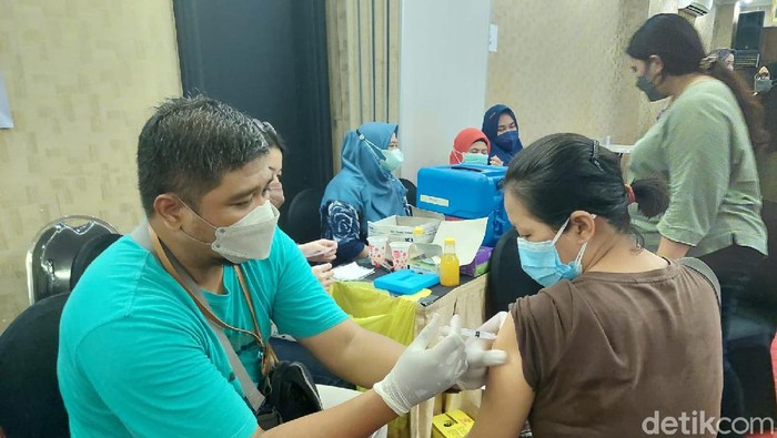 Vaksinasi COVID-19 digelar di Hotel Grand Darmo Suite by Amithya, Surabaya. Warga yang menjalani vaksinasi mendapat sembako.