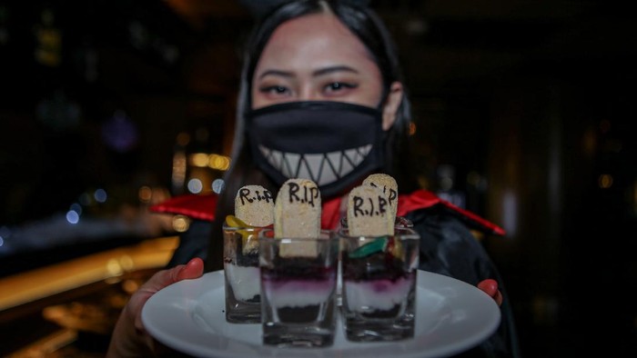 Pekerja berkostum Halloween menyajikan makanan di restoran JHL Solitaire, Tangerang, Banten, Sabtu (30/10/2021). Restoran menyajikan nuansa Halloween untuk memeriahkan perayaan dan menjadi daya tarik tersendiri bagi pengunjung. ANTARA FOTO/Fauzan/rwa.