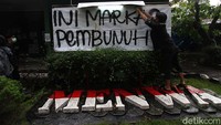 Massa memasang spanduk bertuliskan Ini markas pembunuh