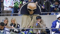 Pemandangan unik terlihat di tengah pertandingan football yang digelar di kawasan Seattle, Washington, AS. Salah satu pengunjung tampak mengenakan kostum alien yang sukses menarik perhatian penonton lainnya. AP Photo/Ted S. Warren.  