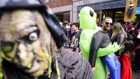 Sejumlah warga di kawasan Salem, Massachusetts, Amerika Serikat, turun ke jalan dengan mengenakan kostum bertema Halloween, pada Minggu (31/10/2021) waktu setempat. AP Photo/Steven Senne.