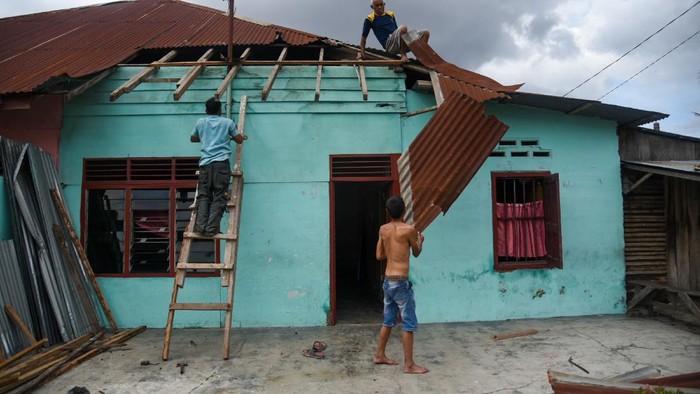 DAMPAK ANGIN PUTING BELIUNG DI MEDAN Sejumlah warga mengamati rumah yang rusak akibat angin puting beliung di Jalan Menteng 2 Lingkungan 12, Medan Denai, Kota Medan, Sumatera Utara, Minggu (31/10/2021). Bencana angin puting beliung yang menerjang daerah tersebut pada Sabtu (30/10) malam mengakibatkan 11 rumah rusak. ANTARA FOTO/Fransisco Carolio/Lmo/foc.