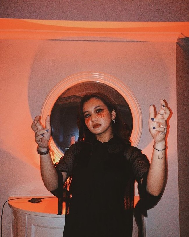 Dea Anissa tampil dengan wajah yang seram untuk perayaan Halloween. Dea tampak mengenakan busana serba hitam. Kuku tangannya pun diwarnai dengan warna hitam. Bagaimana menurutmu penampilan Dea? Foto: Instagram