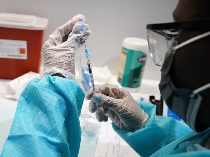 A health care worker fills a syringe with the  Pfizer COVID-19  vaccine, Thursday, July 22, 2021, at the American Museum of Natural History in New York. The museum moved their vaccination site from the Hall of Ocean Life where the famous 94-foot-long model of a blue whale is hanging from the ceiling to a smaller adjacent gallery. New York City is closing the big vaccination sites to focus on areas with low vaccination rates. (AP Photo/Mary Altaffer)