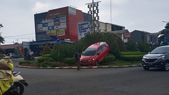 Mobil nyangkut di taman Karawang.