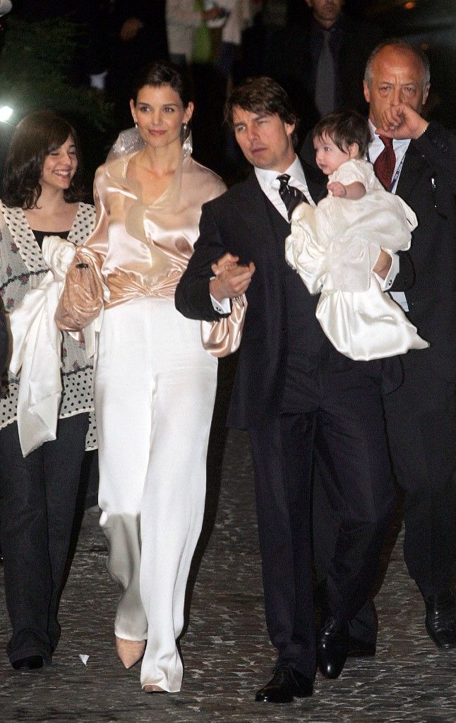 US superstars Tom Cruise (R) and his fiancee Katie Holmes holding their daughter Suri arrive at a restaurant in central Rome, 16 November 2006. They are expected to marry at the weekend, in the Odescalchi Castle, in the lakeside town of Bracciano near the Italian capital. (Photo by GIULIO NAPOLITANO / AFP)