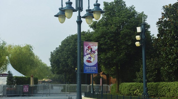 Disneyland employees gather to wait for their COVID-19 tests at the Shanghai Disney Resort in Shanghai, China on Sunday, Oct. 31, 2021. Fireworks boomed as the visitors at Shanghai Disneyland waited for their COVID-19 test results, surrounded by healthcare workers dressed from head to toe in the white protective suits. Shanghai Disneyland suddenly announced Sunday evening that they were no longer accepting any visitors and they were cooperating with an epidemiological investigation from another province. They then locked down the park, as Shanghai city healthcare workers and police rushed to the scene to conduct a mass testing. (Chinatopix via AP)