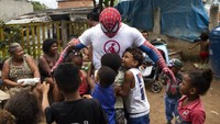Dengan kostum superhero, relawan ini juga menghibur anak-anak di wilayah tersebut.  