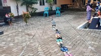 Antrean sandal mengular dan berkelok-kelok di sepanjang halaman Puskesmas Siwalan. 