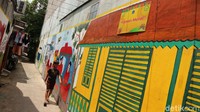 Mural bertema betawi menghiasi jalan kampung yang tampak bersih.