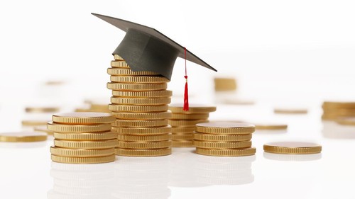 Metallic coins with a black mortarboard forming a financial graph over white background. Savings concept. Horizontal composition with selective focus and copy space.