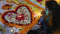 Tak sedikit warga yang datang bersama anggota keluarga mereka lainnya untuk berziarah dan menghiasi makam keluarganya yang telah meninggal dunia. AP Photo/Mahesh Kumar A.