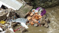 Material bangunan beton, terlihat masih berserakan di aliran Sungai Cibereum.