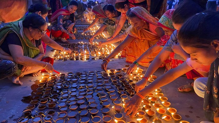 People light lamps on the banks of the river Saryu in Ayodhya, India, Wednesday, Nov. 3, 2021. Over 900,000 earthen lamps were lit and were kept burning for 45 minutes as the north Indian city of Ayodhya retained its Guinness World Record for lighting oil lamps as part of the Diwali celebration – the Hindu festival of lights. (AP Photo/Rajesh Kumar Singh)