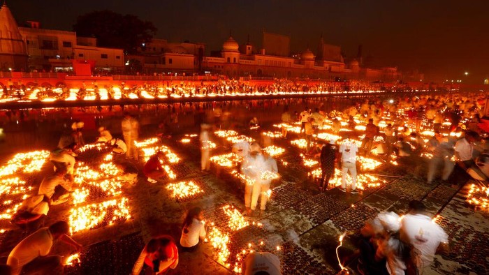 People light lamps on the banks of the river Saryu in Ayodhya, India, Wednesday, Nov. 3, 2021. Over 900,000 earthen lamps were lit and were kept burning for 45 minutes as the north Indian city of Ayodhya retained its Guinness World Record for lighting oil lamps as part of the Diwali celebration – the Hindu festival of lights. (AP Photo/Rajesh Kumar Singh)