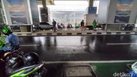 Seorang pedagang jas hujan plastik tampak wara-wiri menawarkan dagangannya.  Foto: Andhika Prasetia