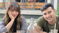 Santai di kafe sambil menikmati makanan dan minuman enak juga sering dilakukan pasangan suami istri ini. Terlihat mereka memberikan senyum manis.