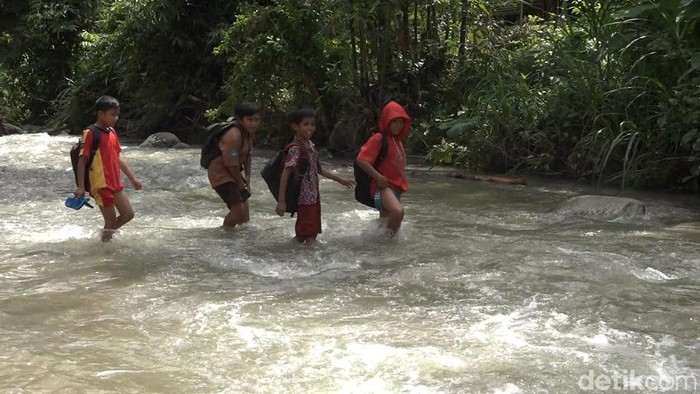 Siswa SD di Polman, Sulbar bertaruh nyawa seberangi sungai berarus deras akibat jembatan ambruk diterjang banjir bandang. (Abdy/detikcom)