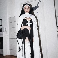 Agnez menggunakan pakaian biarawati yang telah dimodifikasi. Kostum tersebut memiliki unsur seksi dengan belahan-belahan di area tertentu. Dia pun memadankannya dengan kesan modern yakni menggunakan boots tinggi warna putih. Foto: dok. Instagram/@agnezmo