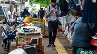 Pejalan kaki melintasi pasar loak di Kebayoran Lama, Jakarta Selatan, Jumat (5/11/2021).