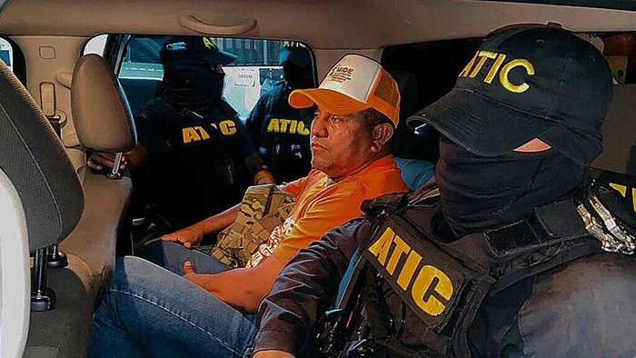 Presidential candidate Santos Rodriguez is escorted by Honduran authorities following his arrest over money laundering (Handout/AGENCIA TECNICA DE INVESTIGACION CRIMINAL de Honduras/AFP)