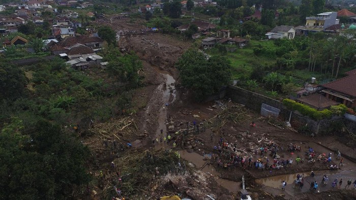 Potret Pencarian Korban Banjir Bandang Kota Batu dari Udara Foto udara Tim SAR gabungan bersama relawan dan warga membersihkan endapan lumpur saat pencarian korban akibat banjir bandang di Bulukerto, Kota Batu, Jawa Timur, Jumat (5/11/2021). Berdasarkan laporan sementara dari BPBD Kota Batu hingga hari kedua pencarian korban banjir bandang, tim SAR berhasil menemukan enam jenazah korban dan tiga korban masih dalam proses pencarian. ANTARA FOTO/Zabur Karuru/aww.