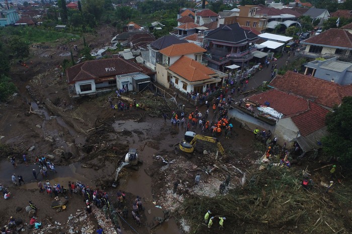 Foto udara Tim SAR gabungan bersama relawan dan warga membersihkan endapan lumpur saat pencarian korban akibat banjir bandang di Bulukerto, Kota Batu, Jawa Timur, Jumat (5/11/2021). Berdasarkan laporan sementara dari BPBD Kota Batu hingga hari kedua pencarian korban banjir bandang, tim SAR berhasil menemukan enam jenazah korban dan tiga korban masih dalam proses pencarian. ANTARA FOTO/Zabur Karuru/aww.