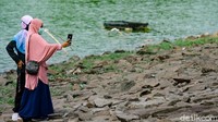 Berjalan mengitari Situ Gintung sekaligus menikmati pemandangan. Tidak jarang, warga berfoto ria di lokasi. 
