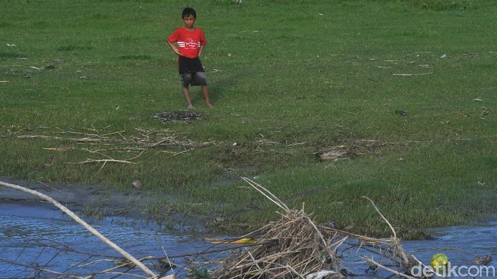 BERMAIN SEPAKBOLA DI DEKAT HABITAT BUAYA Seorang anak melihat bolanya yang jatuh di dekat seekor buaya saat bermain disekitar Sungai Palu di Palu, Sulawesi Tengah, Sabtu (6/11/2021). Masyarakat diminta untuk lebih waspada saat beraktivitas di sekitar habitat buaya liar yang dapat mengancam keselamatan. ANTARA FOTO/Mohamad Hamzah/aww.