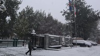 Seorang staf berjalan memasuki halaman Kedutaan Besar RI yang berselimut salju, di Beijing, China, Minggu (7/11/2021).