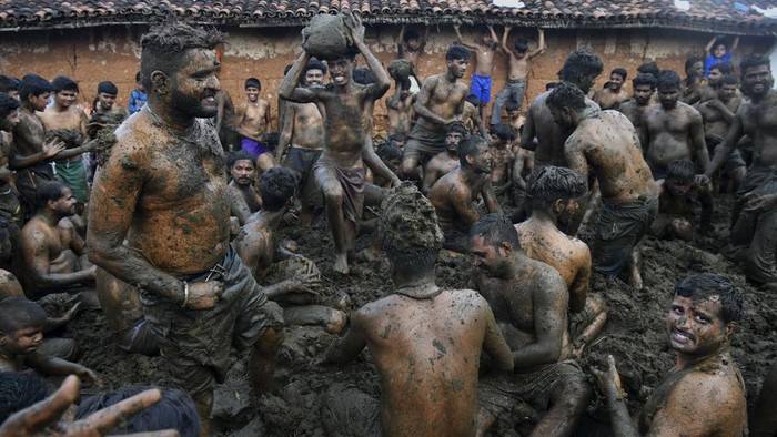 Men fling cow dung at each other during the annual 'Gore Habba' festival, where people throw and smear each other with cow dung, in Gumatapura village situated some 180 Km south of Bangalore on November 6, 2021. (Photo by Manjunath Kiran / AFP)