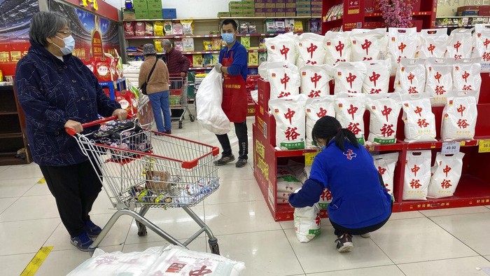 An employee attends to a customer at a supermarket in Beijing, China, Wednesday, Nov. 3, 2021.  A recent seemingly innocuous government recommendation for Chinese people to store necessities for an emergency quickly sparked scattered instances of panic-buying and online speculation of imminent war with Taiwan. (AP Photo/Ng Han Guan)