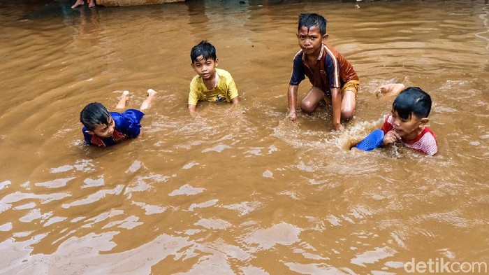 Duh! Bocil Asyik Main di Lokasi Banjir Kembangan Jakbar Jalan Haji Briti B di Kelurahan Kembangan Selatan, Jakbar, banjir, Senin (6/11). Anak-anak malah memanfaatkan situasi dengan bermain air banjir.