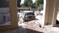 Tampak kendaraan dan muka rumah milik al-Khadimi rusak parah.   