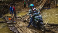  Jembatan darurat yang berbahan kayu dan bambu tersebut tampak licin.
