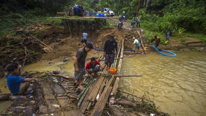 Potret Perjuangan Warga Lintasi Jembatan Darurat di Kalsel Jembatan utama Desa Murung B, Hantakan, Kalimantan Selatan, ambruk terbawa arus luapan sungai. Kini warga terpaksa menyeberang melewati jembatan darurat yang licin.
