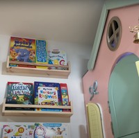 Pada bagian salah satu dindingnya terdapat rak-rak yang digunakan untuk meletakkan buku-buku. Tepat di sampingnya terdapat rumah-rumahan yang dilengkapi dengan lonceng kecil di bagian depannya. Foto: YouTube/NisNaz Channel