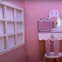 Sedangkan untuk rumah-rumahan yang terletak di bagian atas, bagian dalamnya tampak didominasi warna merah muda. Terdapat sebuah tas makeup kecil dengan glitter berwarna merah muda, serta bangku dan meja rias berwarna senada. Foto: YouTube/NisNaz Channel