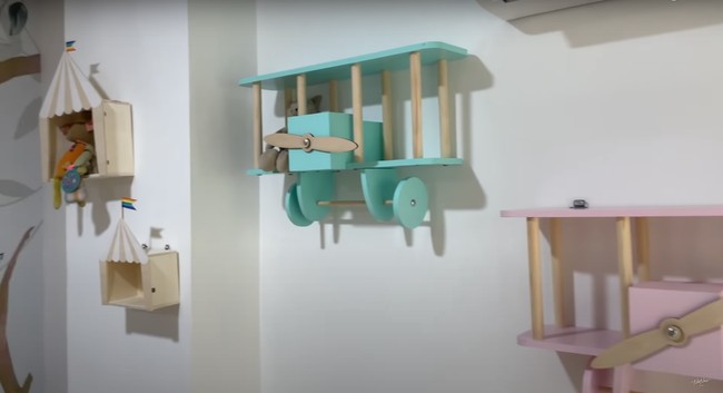 Di bagian temboknya juga terdapat dekorasi berupa pesawat-pesawatan yang terbuat dari kayu dan diwarnai dengan warna-warna senada dengan tema di ruangan bermain tersebut. Foto: YouTube/NisNaz Channel