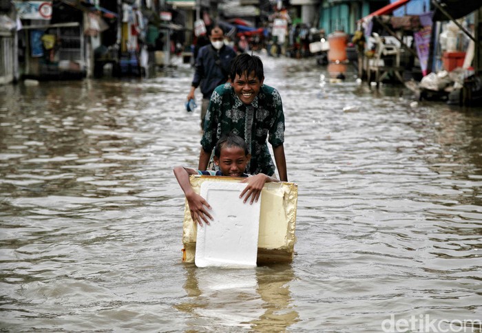 Sejumlah anak-anak pesisir di kawasan Muara Angke, Jakarta Utara, tampak semringah saat bermain di tengah banjir rob.