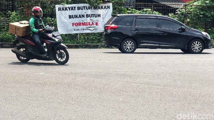 Spanduk Penolakan Formula E di Jakarta Barat Pengendara melintas di Kawasan Kedoya, Jakarta Barat, Senin (8/11/2021). Sebuah spanduk bertuliskan 'Rakyat Butuh Makan Bukan Butuh Formula E' masih terpajang di kawasan tersebut.