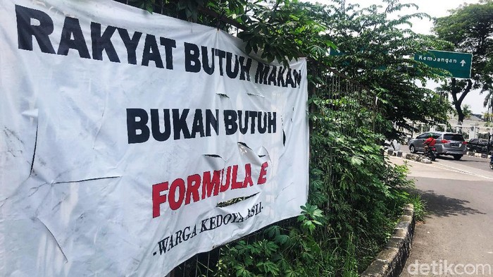 Pengendara melintas di Kawasan Kedoya, Jakarta Barat, Senin (8/11/2021). Sebuah spanduk bertuliskan 'Rakyat Butuh Makan Bukan Butuh Formula E' masih terpajang di kawasan tersebut.