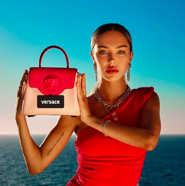 Inilah potret Delilah saat menjadi model untuk kampanye Versace. Berbalut dress  fuchsia, wanita 23 tahun itu memamerkan tas Versace. Foto dok. Instagram/@delilahbelle