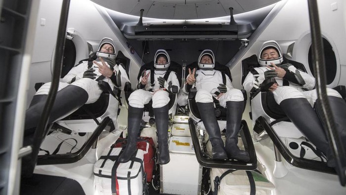 In this photo provided by NASA, from left to right, European Space Agency astronaut Thomas Pesquet, NASA astronauts Megan McArthur and Shane Kimbrough, and Japan Aerospace Exploration Agency astronaut Akihiko Hoshide gesture inside the SpaceX Dragon spacecraft onboard the SpaceX GO Navigator recovery ship shortly after having landed in the Gulf of Mexico off the coast of Pensacola, Fla., Monday, Nov. 8, 2021. The astronauts returned to Earth on Monday to end a 200-day space station mission that began last spring. (Aubrey Gemignani/NASA via AP)