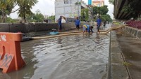 15 orang personel Suku Dinas Sumber Daya Air (SDA) Jakut dan 3 unit pompa air dengan kapasitas 5.000 liter per detik yang dikerahkan untuk membuang air dari jalanan ke Kali Ancol. (Wildan-detikcom)