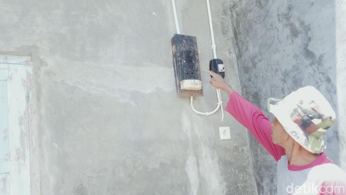 Ketua RT Sukiman menunjukkan kWh meter yang dicabut PLN usai memberikan denda Rp 7,6 juta
