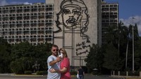 Sepasang turis Rusia berfoto selfie di depan ikon revolusioner Kuba, Ernesto “Che” Guevara di Revolution Plaza di Havana. (Ramon Espinosa/AP)