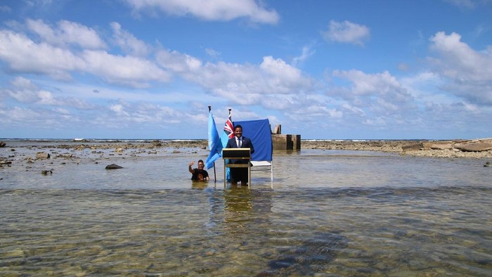 Menlu Tuvalu Simon Kofe Menteri Luar Negeri Tuvalu, Simon Kofe, memberikan pidato untuk Konferensi Perubahan Iklim (COP26) di pantai laut. Kofe berdiri menceburkan diri dengan lutut terendam air laut, sembari ditemani bendera Perserikatan Bangsa-Bangsa (PBB) dan bendera kebangsaan negara itu.